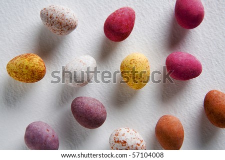 birds eye view of chocolate  eggs, all different colours on white back ground