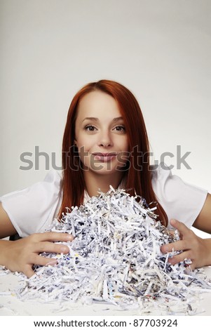 woman with a pile of shredded paper in front of her on her desk