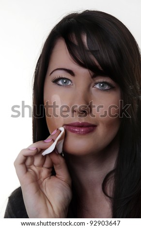 woman wiping what looks like sun tan off her face