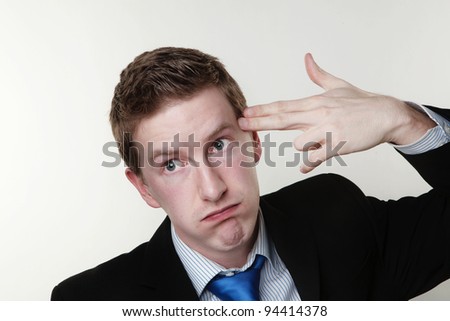 business man point his fingers to his head as if he about to shoot himself