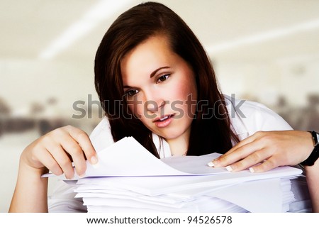 woman at desk looking and thinking about all the paper work she needs to do