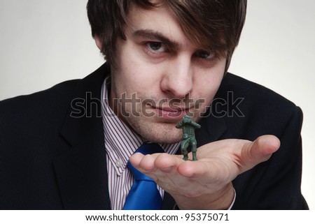 close up detail shot of business man playing with toy soldiers in his hand