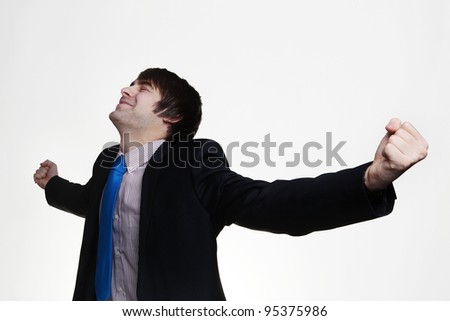 happy businessman with his arms out wide looking up very pleased with himself