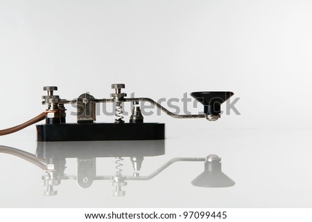 still life image of a morse code key on a white background