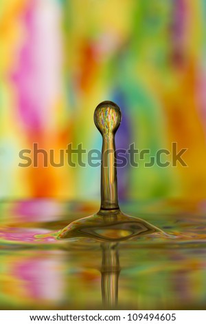 Multi-colored tie dye reflected in oblong water drop