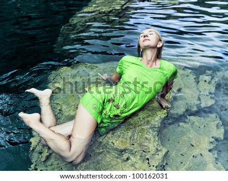 Woman like mermaid in wet dress in lake