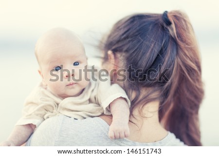 Young mother with baby on the beach