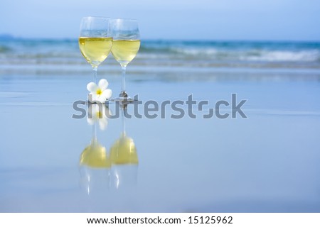 Reflection of two glasses of white wine on tropical beach