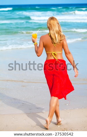Woman with juice on the tropical beach