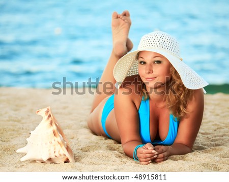Young woman sunbathing on the tropical beach