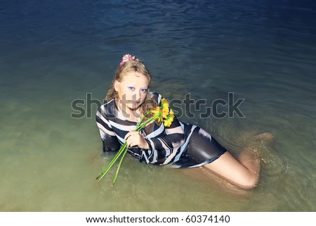 Beautiful woman with flowers in the sea