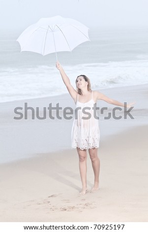 Beautiful woman near the stormy ocean at rain