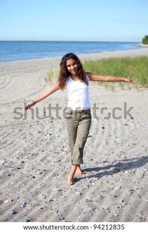 A girl walks a straight line in the sand at the beach