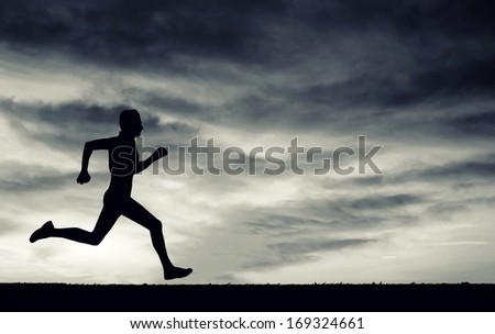 Silhouette of running man on cloudy sky. Black and white. Element of design.