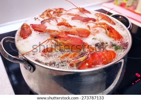 Fresh crayfish are cooked in a pot with boiling water.