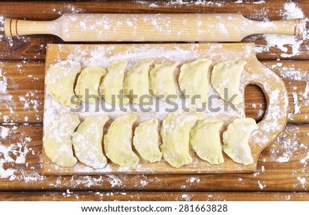 Vareniki with potatoes on a cutting board before cooking. Dumplings on a cutting board.