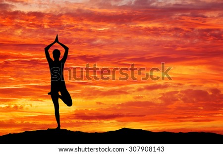 Silhouette of a woman Yoga in the evening. Woman doing Yoga at sunset