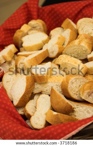 Freshly cut slices of french loaf on a red cloth in a basket
