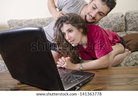 Couple looking at notebook pc in living room