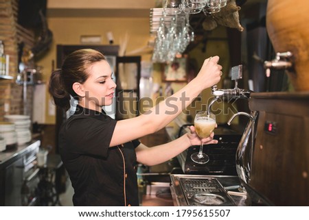 Foto Bild Kellnerin zapft Zapfhahn-Bier in einer Bar