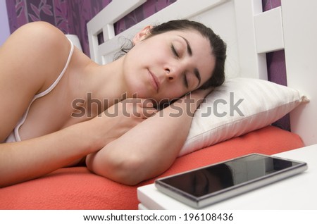 Beauty woman sleeping near to her alarm clock smart phone or waiting a phone call.