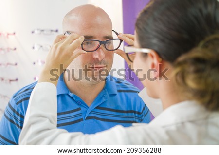Optical glasses test on man, professional optometrist woman