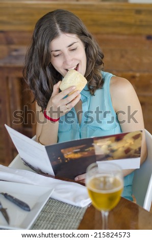 Anxiety woman reading restaurant menu card and eating bread