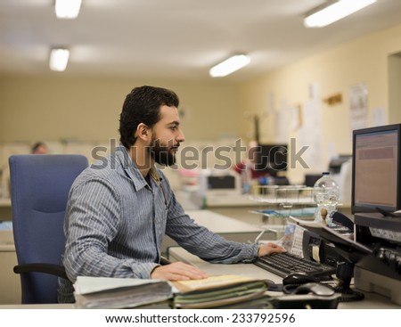 Image of bearded hipster office clerk working at office