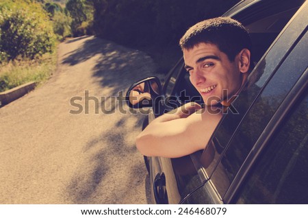Young man in black car ready for trip looking at the view