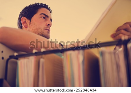 Closeup image of young office clerk worker looking a file