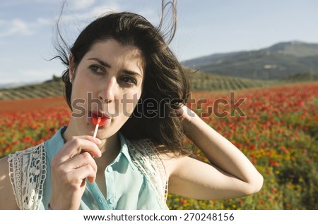 Casual woman eating candy at outdoors with sunlight