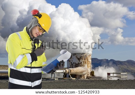 Geothermal engineer and geologist reading data from a list at a gothermal power plant in Iceland, creating hot water and sustainable energy from natural resources