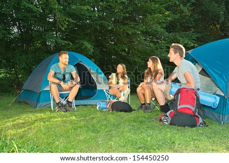 A group of friends sitting in front of tents
