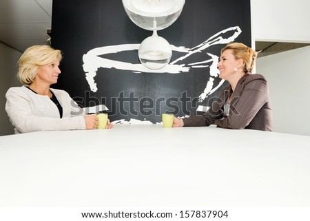 Female entrepreneurs discussing while having coffee at table in office