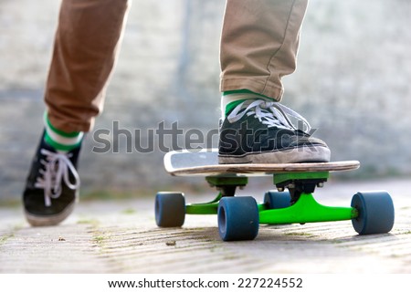 Skateboarder setting his board in motion by pushing off with one foot in an urban setting, representing the youth (sub) culture