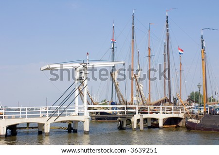 The old harbor in Volendam, the Netherlands, with a drawbridge, and old commercial sailing ships moored in the harbor