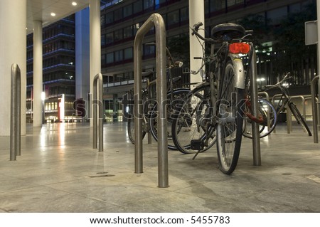Bikes parked outside one of the ministries in the Hague, the Netherlands at night, one with a flat tire