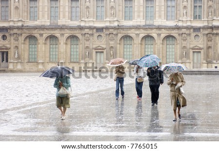 Pedestrians, rushing for cover at the Louvre during a heavy shower.
