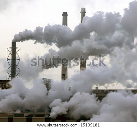 A heavy industry production plant with steam and fumes from various exhausts