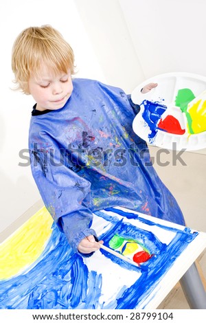 Young painter working on a painting with poster paint, coloring a traffic light