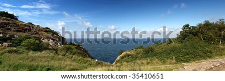 Panoramic ocean view wedged in between two hills and a steep cliff