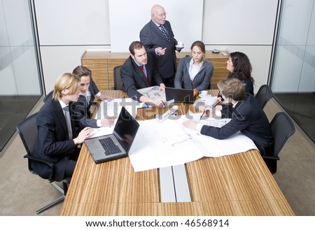 A group of six junior associates during a design team meeting with a senior manager