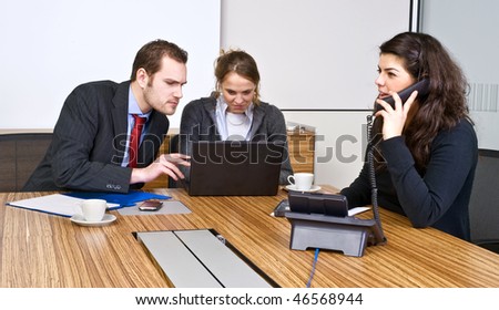 A small business team in a cubicle conference room during a meeting