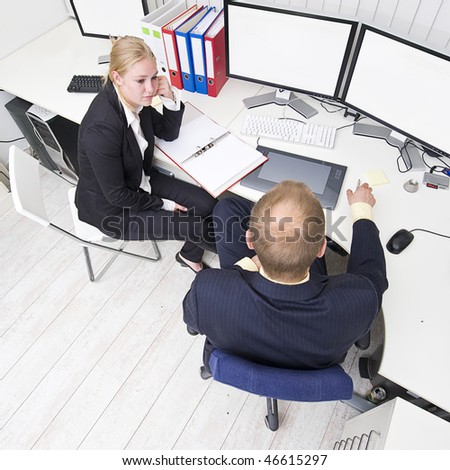 Two colleagues discussing business during a small meeting