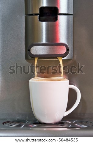 Pad coffee maker brewing a porcelain cup of hot coffee, about to overflow