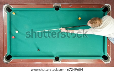 Pool player reaching for a shot, seen from above