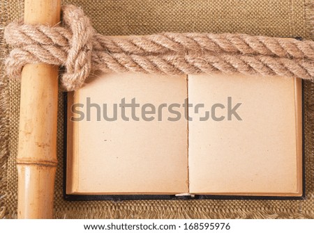 Knot sea and old book on background of the old fabric