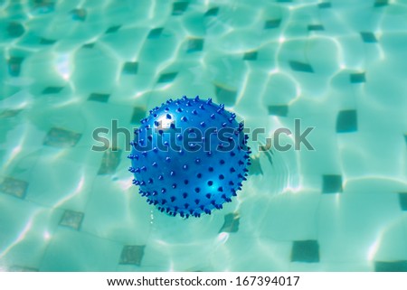 Blue spike ball floating in a swimming pool