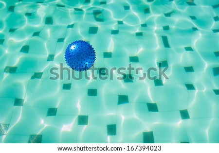Blue spike ball floating in a swimming pool