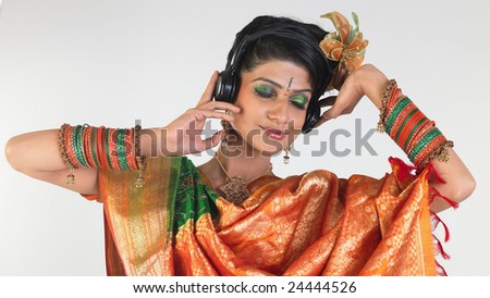 woman hearing music with rich silk-sari and colorful bangles